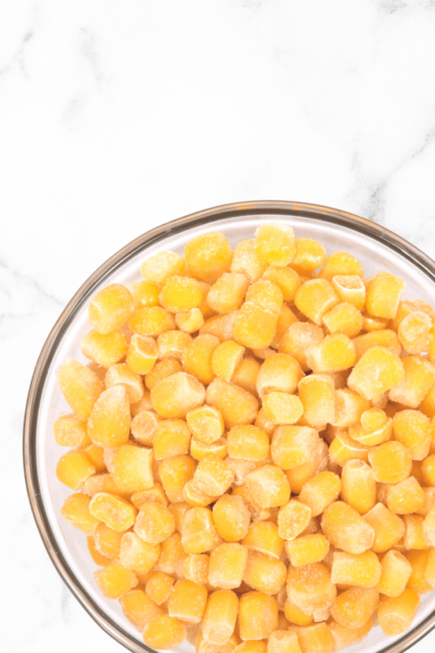 corn in a clear bowl on white marble counter